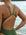 Close back strap view of a female athlete wearing a JAYD Swimwear athletic one piece swimsuit, Apsley in Olive green, standing on a beach.