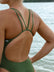 Close back strap view of a female athlete wearing a JAYD Swimwear athletic one piece swimsuit, Apsley in Olive green, standing on a beach.