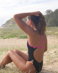 Side view of Zambia One Piece Athletic Swimsuit in Black & Pink Sorbet by JAYD Swimwear