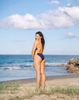 JAYD Swimwear ambassador Madi Armstrong designed a collection with JAYD and Cure Cancer. She is wearing the Ibiza one piece in the colour Acai with contrasting Kiwi straps and hip detailing
