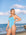 Woman wearing JAYD Albi one piece swimsuit in Waikiki blue with contrasting Cancun cross back straps on the beach