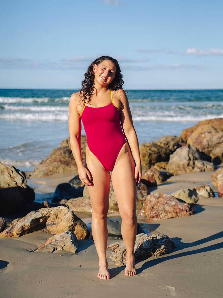 Tart pink one piece swimwear with Daffodil yellow strap and side cutout detail, JAYD Lennox style. Worn by JAYD athlete and open water swimmer Madi Armstrong.