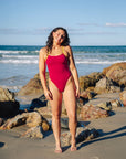 Tart pink one piece swimwear with Daffodil yellow strap and side cutout detail, JAYD Lennox style. Worn by JAYD athlete and open water swimmer Madi Armstrong.
