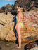 Woman wearing JAYD Swimwear Zambia one piece swimsuit in Kiwi green with contrasting Tart straps. Suit designed to raise awareness for Cure Cancer.