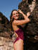 Athlete Molly wears the JAYD swimwear fixed back one piece called Zambia in the colour Sangria. The contrasting cut out straps are neon orange. This piece is designed to stay in place.