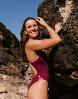Athlete Molly wears the JAYD swimwear fixed back one piece called Zambia in the colour Sangria. The contrasting cut out straps are neon orange. This piece is designed to stay in place.