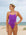 Front view of a female athlete wearing a JAYD Swimwear athletic one piece swimsuit, Riva in Murasaki purple, standing on a beach.