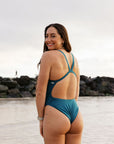 Athlete Jenaya wears a fixed back one piece in the colour cove. This onesie is called the Soraya and is designed by JAYD Swimwear. JAYD helps you dive in with confidence.