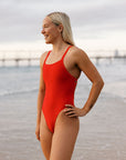Olympian Ella wears the fixed back one piece by JAYD swimwear called Soraya int he colour Ruby. She is wearing it for leisure at the beach.