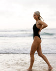 JAYD Swimwear design a fixed back wider strapped one piece called Soraya. Athlete Keira wears hers at the beach as it is both flattering and functional and offers a mid bum coverage.