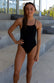 JAYD Swimwear, athletic one piece called Tallow in the colour black, standing at the swimming pools