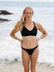 Emma Woods wearing the black Tazzie Top by JAYD Swimwear, showing the supportive front design of the chlorine-resistant performance swim top made for surf athletes and training.
