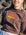 Close-up of a woman wearing a brown JAYD Swimwear oversized tee with a retro orange and yellow JAYD Swimwear logo print on the front.