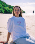 White oversized JAYD Swimwear t-shirt with a pink cowgirl boots and cactus back print, a fun boxy fit tee for beach days and lounging.