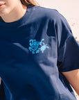 JAYD Swimwear navy boxy fit t-shirt featuring a blue ocean-inspired back print, styled with denim jeans for an oversized, laid-back beach look.