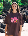 Brown oversized JAYD Swimwear t-shirt with a pink hibiscus floral front print, an everyday boxy fit tee for beach days and tropical getaways.
