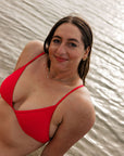 Athlete Jenaya wears the Triangle tie-back top by JAYD Swimwear in the colour Ruby. Top is made from chlorine resistant material.