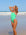 Female swimmer in a Meadow green athletic JAYD Swimwear Zambia one piece swimsuit standing on a beach with ocean waves in the background