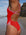 Close side view of a female swimmer wearing a Ruby red JAYD Swimwear one piece swimsuit with pink Fairy Floss straps, standing on a beach.