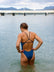 Back view of model wading in the water wearing JAYD Swimwear athletic one piece Lennox in Nordic Blue.