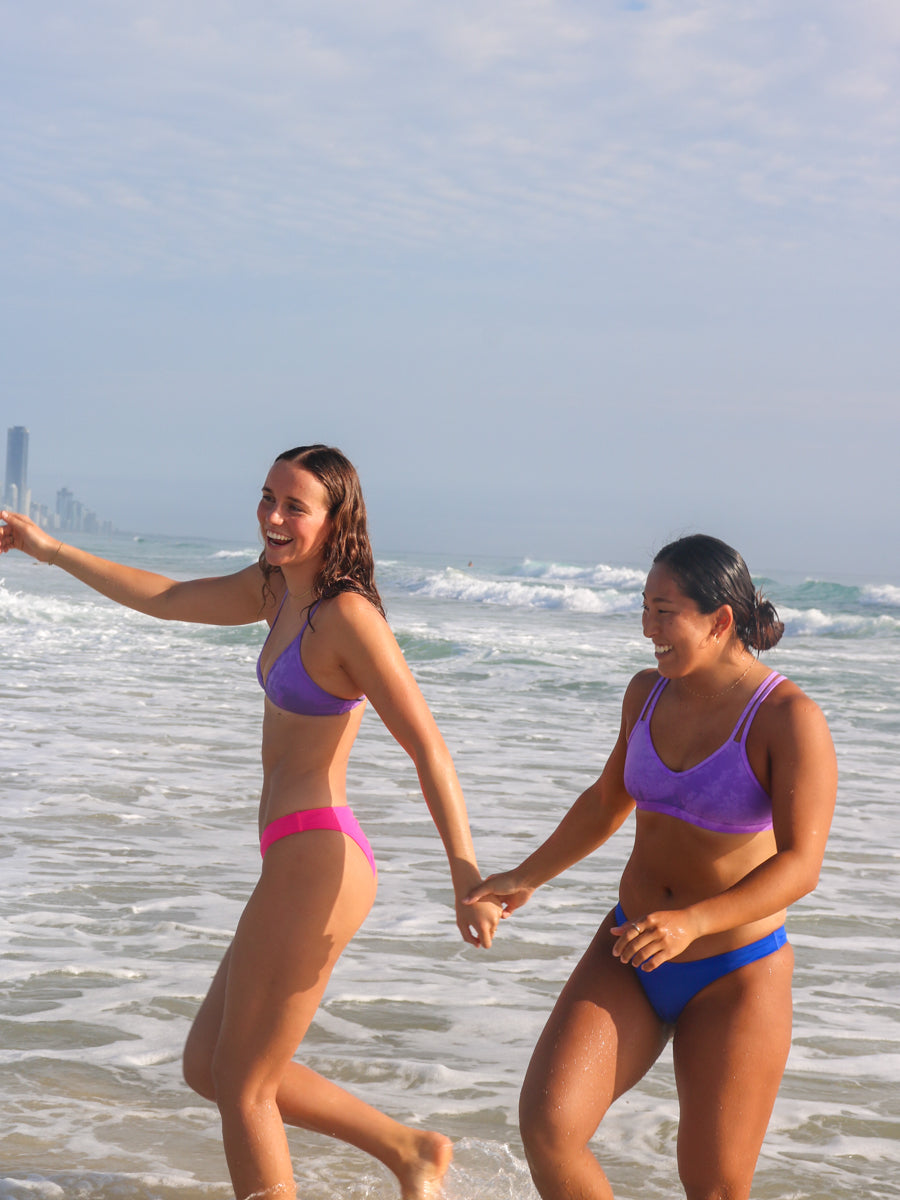 Side view of seamless, athletic, cheeky coverage JAYD Swimwear Minnie bikini bottoms in Pink Sorbet.