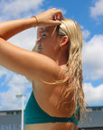 Close side view of athletic bikini top Tazzie in Cove Green by JAYD Swimwear