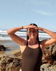Triathlete Charlotte wears JAYD Swimwear's athletic, chlorine resistant one piece called Finley. This piece offers slim coverage and is built for performance. This double strapped fixed back is seen in the colour Cacao.