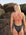 Olympic swimmer, Ella Ramsay, standing near rocks wearing a JAYD Swimwear Airlie One Piece in Carbon.