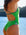 Close side view of model on beach wearing JAYD Swimwear athletic one piece swimsuit Zambia in Moss Green.