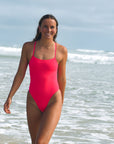 Front view of JAYD Swimwear tie back athletic one piece: Isla in Fiesta Pink