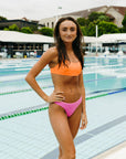 Front view of athletic fixed-back Torquay bikini top in Neon Orange by JAYD Swimwear.