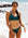 Female swimmer in Cove Tazzie JAYD Swimwear bikini top standing on a beach with ocean waves in the background.