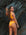 Back view Australian triathlete, Charlotte Derbyshire, wearing a JAYD Swimwear Cali bikini bottom in Sunshine Yellow against a rocky background.