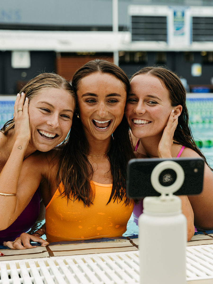 Girls taking a picture with the JAYD magnetic selfie water bottle.