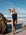 Athlete in a Acai JAYD swimsuit standing on a rocky beach with ocean waves in the background