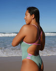 Athlete Sara wears the fixed back Lennox one piece by JAYD Swimwear in the colour Matcha with contrasting fairy floss cut outs. Swimwear designed for performance.