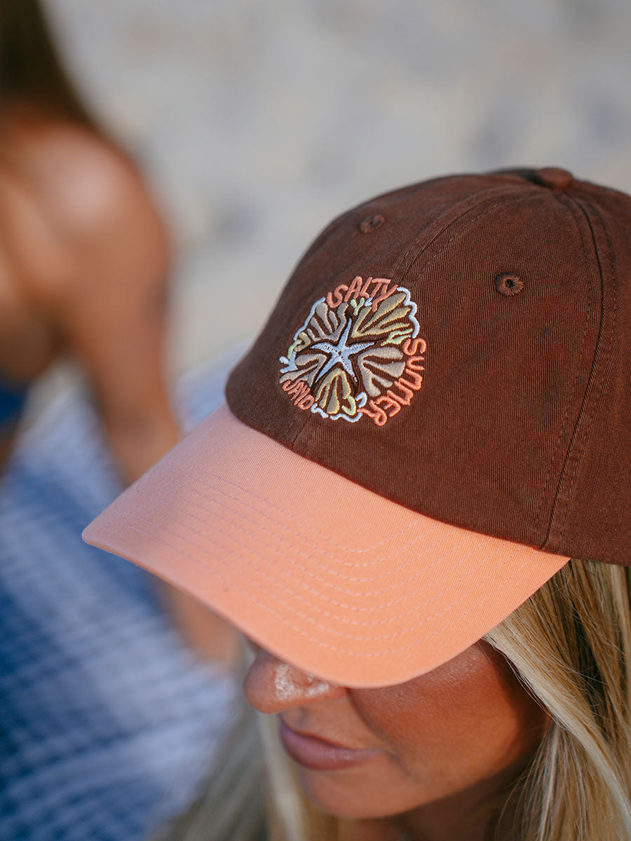 JAYD model wearing the brown and apricot baseball cap with 'Salty Summer' embroidery design.