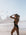 Woman in a Cacao brown JAYD chlorine resistant swimsuit on a beach with kites in the background