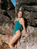Woman in a cove JAYD one piece standing on rocky terrain
