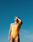 Athletic woman wearing JAYD Swimwear Albi One Piece in Sunshine with high leg cut, supportive design, and chlorine-resistant fabric