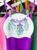 JAYD Swimwear white swim cap featuring three floral jellyfish illustrations, complimented by matching swimsuits.