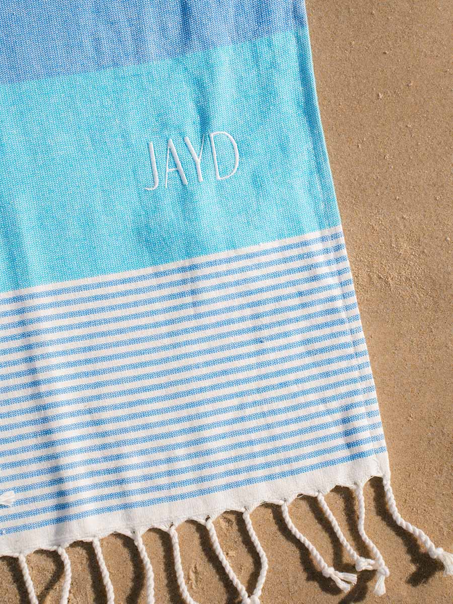 JAYD Swimwear Laguna towel, Woven as a Turkish pestemal with a soft terry back, quick drying, compact and cute with a pattern of contrasting shades of blue.