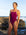 Surf life saving athlete Claudia Slaven standing on a rocky beach with waves breaking in the background wearing the JAYD Swimwear Lennox one piece in sangria with lilac haze straps.