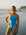 Ski athlete Jenaya Massie standing on a beach at sunrise wearing the JAYD Lennox one piece in Waikiki blue with contrasting Daffodil yellow shoulder straps.