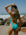 JAYD model wearing the Levanto one piece on a beach in Atlantic, holding a hand over her head and looikng back over her shoulder.