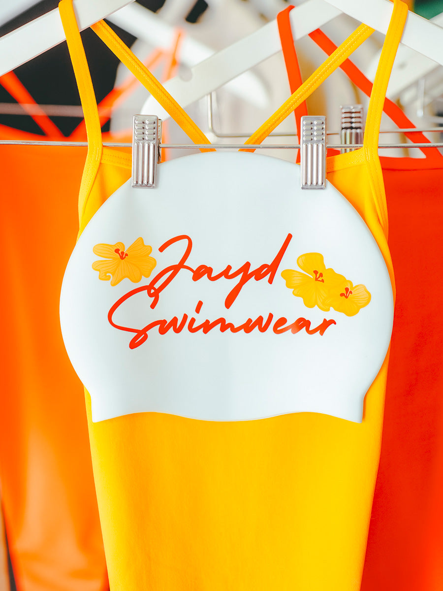 Yellow and orange swimsuit with 'Jayd Swimwear' branding on a white background