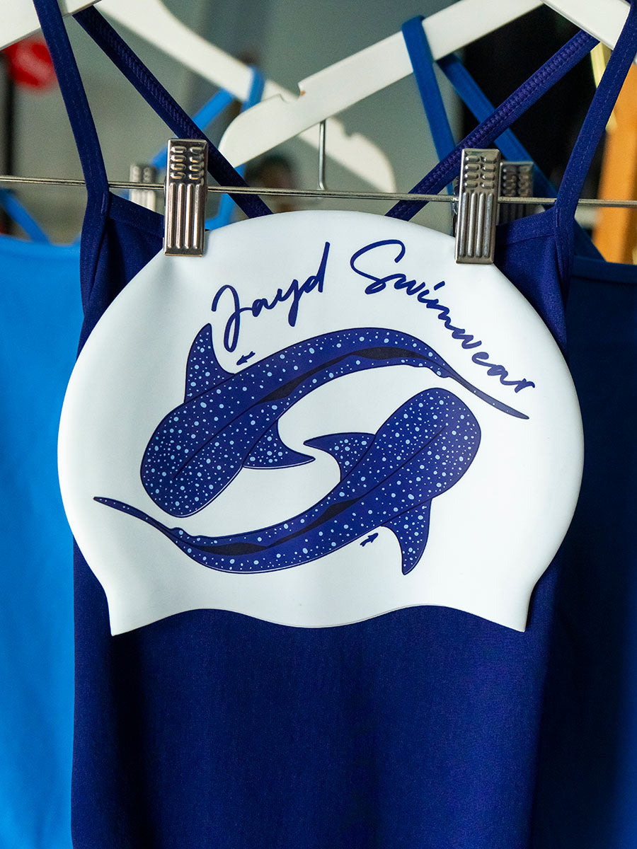 two whale sharks swimming in a circle with JAYD Swimwear branding on a white swim cap.