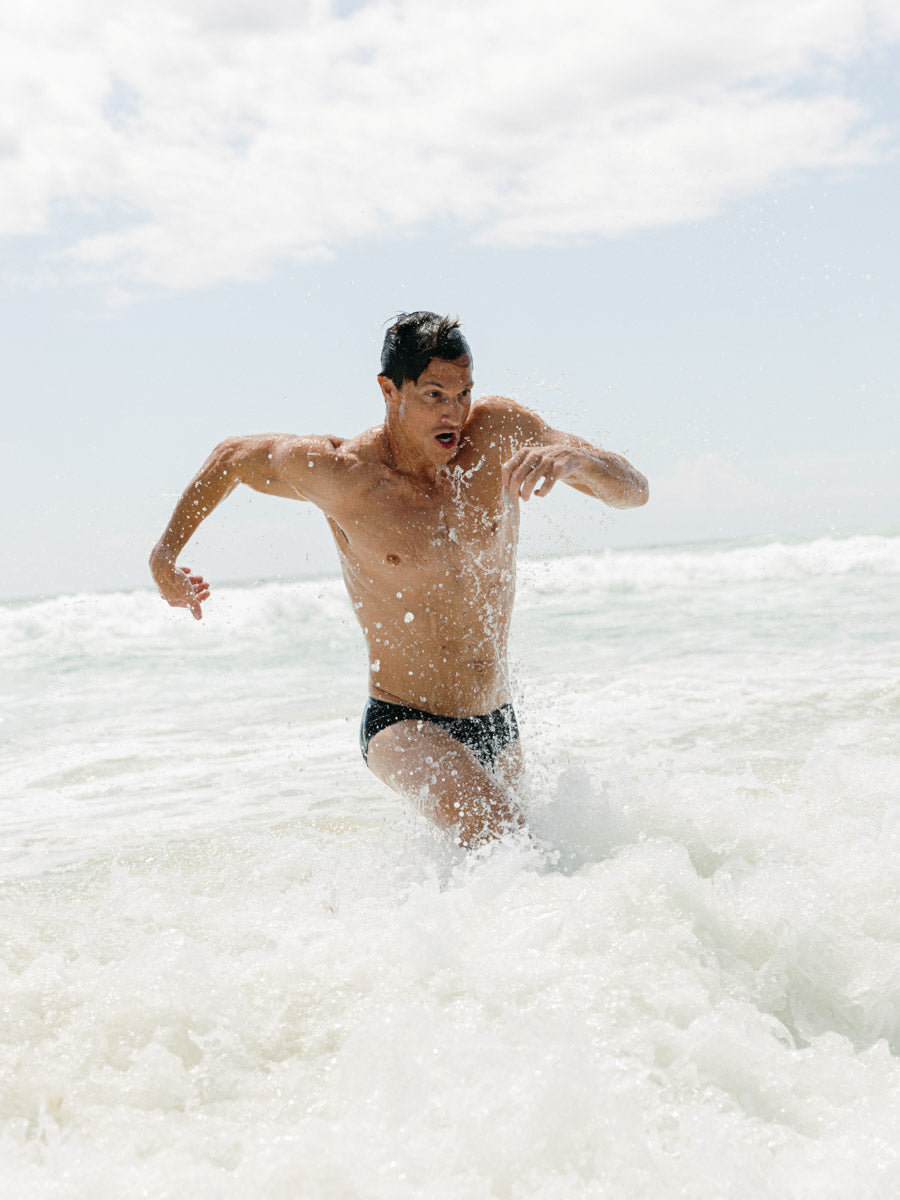 Ocean running in Ramshark Mens Briefs in Black by JAYD Swimwear.