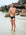 Athlete Wes standing on a rocky beach wearing the JAYD Swimwear men's Ramshark bottoms in black.