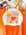 White JAYD Swim cap with colourful collage style illustrations hanging on a rack with swimsuits in the background